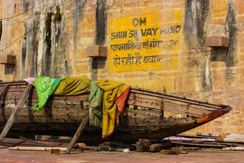 very old and abandoned boat with some dirty clothes on in Varanasi