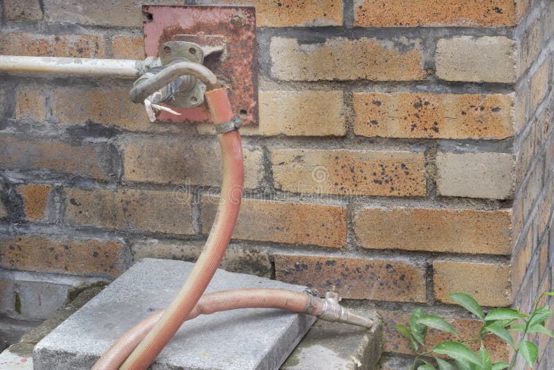 Fire hydrant hose installed at brick wall stock images