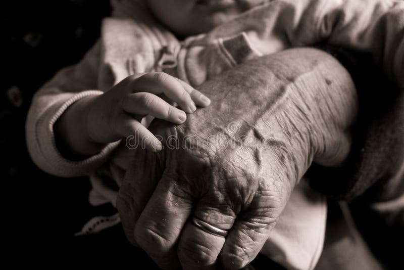 Small baby hand touching and caressing old grandmother hand with wrinkles, symbol of passing generations stock photos Small baby hand touching and caressing old grandmother hand with wrinkles, symbol of passing generations stock photos