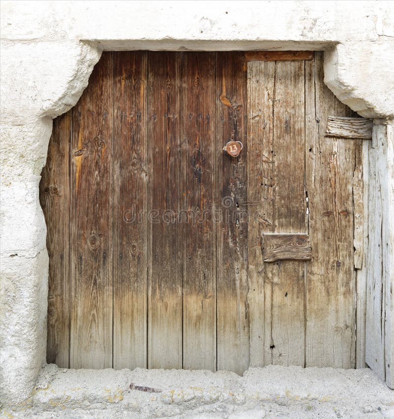 Ancient trapezoidal antique wooden doors with a wooden lock in the middle royalty free stock image Ancient trapezoidal antique wooden doors with a wooden lock in the middle royalty free stock image