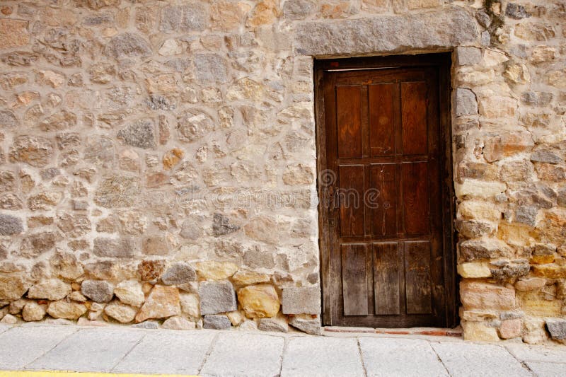 Very old wooden door and stone wall