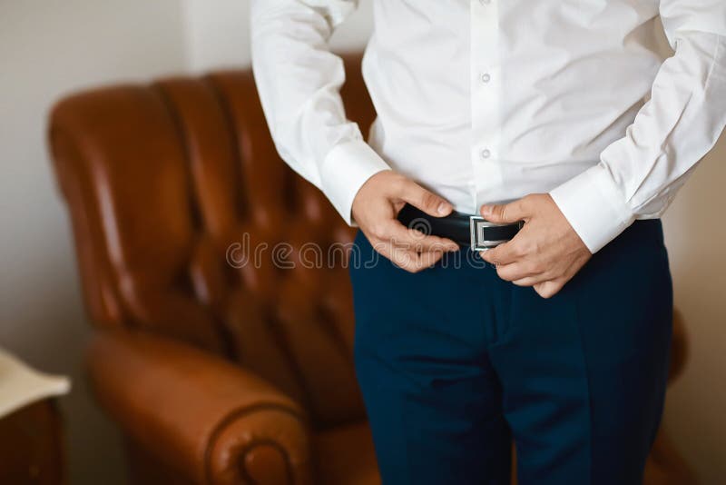 Verzorgt ochtendvoorbereiding, knappe bruidegom die gekleed en voor het huwelijk voorbereidingen treffen, die een riem dragen wor stock afbeelding Verzorgt ochtendvoorbereiding, knappe bruidegom die gekleed en voor het huwelijk voorbereidingen treffen, die een riem dragen wor stock afbeelding