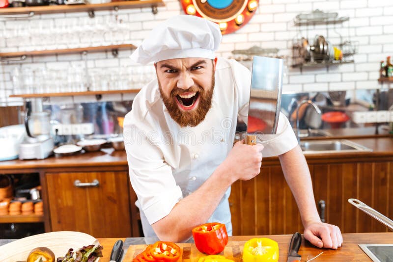 Angry bearded chef cook holding meat cleaver knife and shouting on the kitchen. Angry bearded chef cook holding meat cleaver knife and shouting on the kitchen