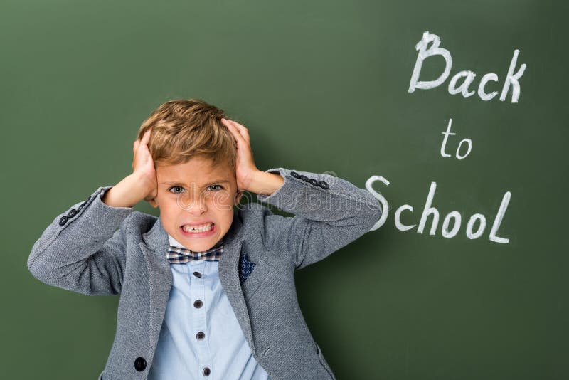 Verärgerter Schüler, der seinen Kopf hält lizenzfreie stockbilder Verärgerter Schüler, der seinen Kopf hält lizenzfreie stockbilder