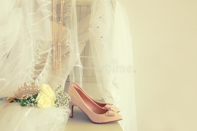Vestido de casamento, sapatas, tiara do diamante do ouro e véu brancos bonitos na cadeira imagem de stock royalty free Vestido de casamento, sapatas, tiara do diamante do ouro e véu brancos bonitos na cadeira imagem de stock royalty free