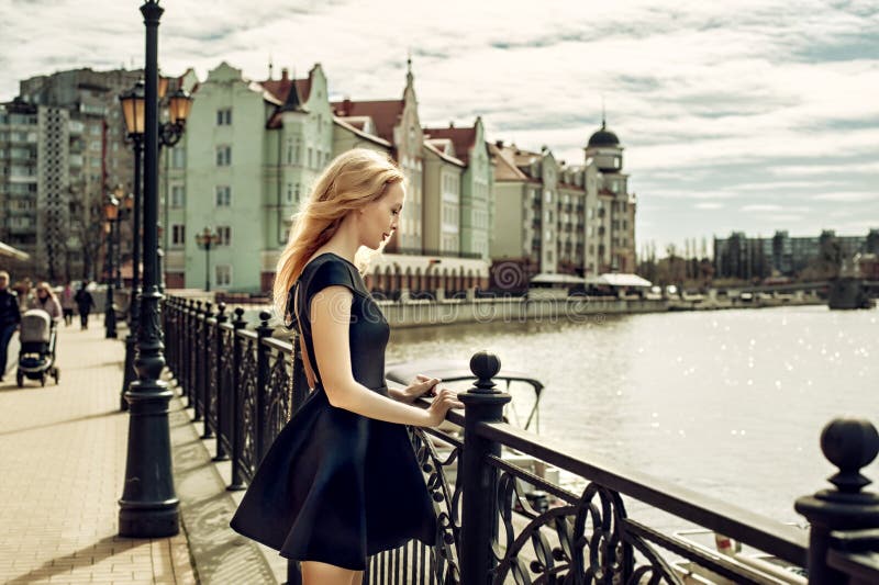 Vestido vestindo do preto da forma da jovem mulher bonita que anda no imagens de stock Vestido vestindo do preto da forma da jovem mulher bonita que anda no imagens de stock