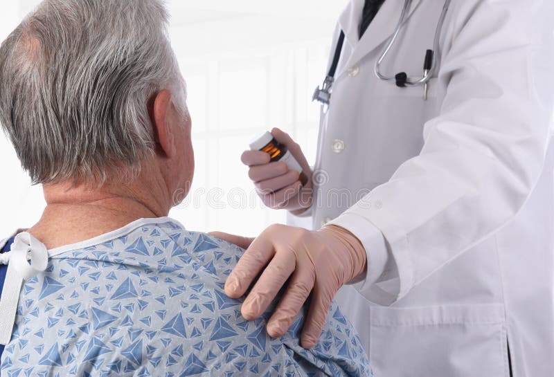 Vestimenta de um idoso doente do sexo masculino usando um vestido hospitalar como médico coloca a mão no ombro, oferecendo confort