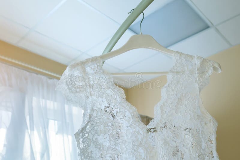 Vestito bianco dal pizzo del boudoir sul gancio fotografia stock Vestito bianco dal pizzo del boudoir sul gancio fotografia stock