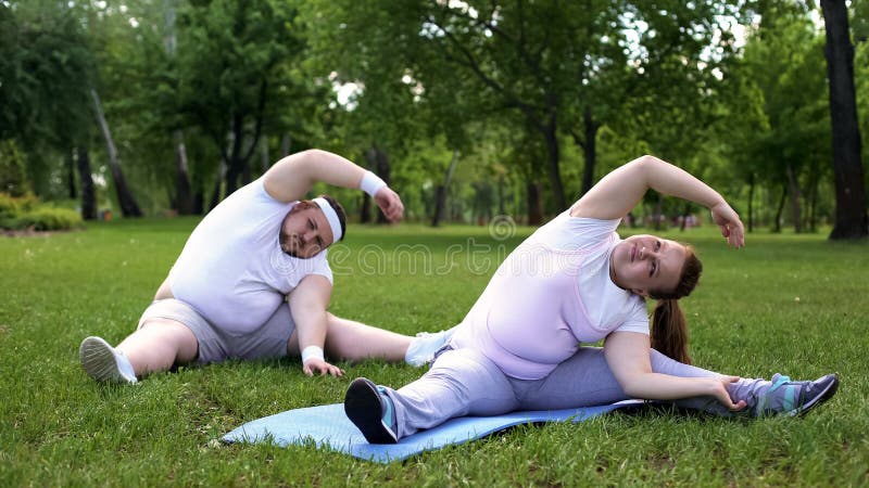 Vet paar die trainingen in park hebben samen, beginners in het programma van het gewichtsverlies royalty-vrije stock afbeeldingen Vet paar die trainingen in park hebben samen, beginners in het programma van het gewichtsverlies royalty-vrije stock afbeeldingen
