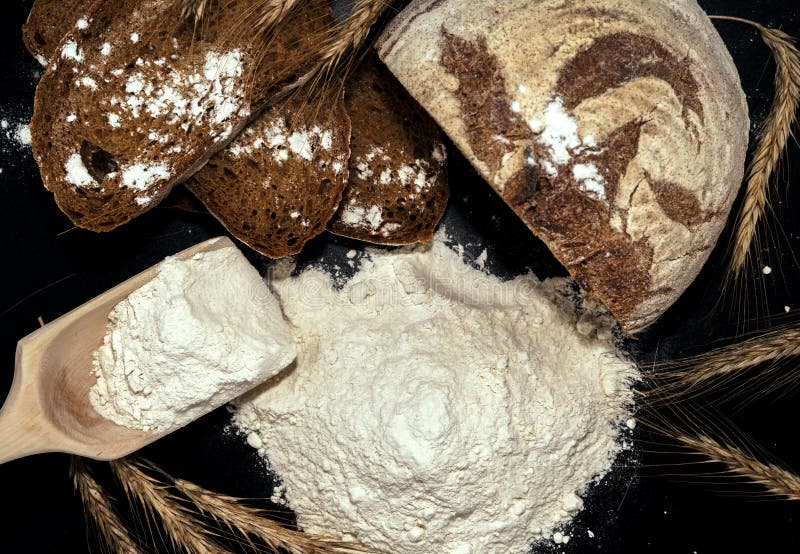Vete, kryddat, med svart bakgrund. Mjöl är den huvudsakliga ingrediensen vid bakning royaltyfria foton