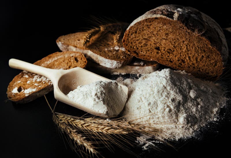 Vete, kryddat, med svart bakgrund. Mjöl är den huvudsakliga ingrediensen vid bakning royaltyfri bild