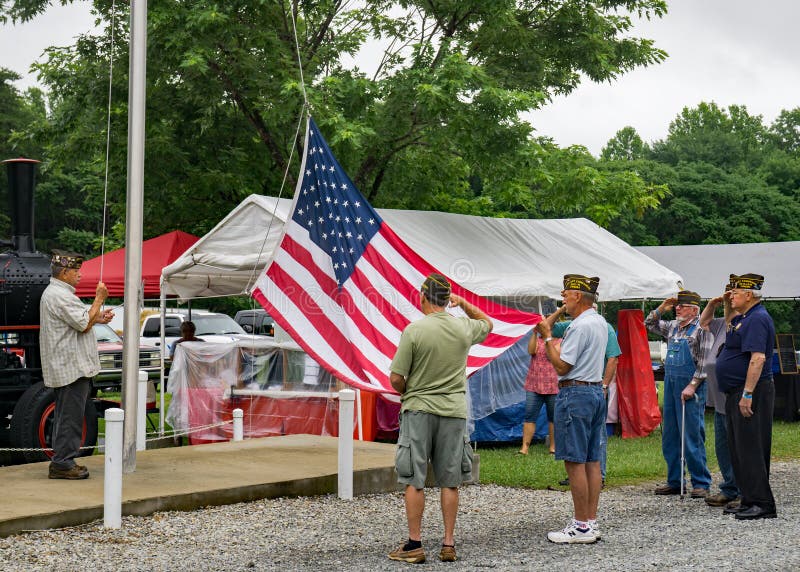 Veterani che alzano la bandiera americana fotografie stock libere da diritti Veterani che alzano la bandiera americana fotografie stock libere da diritti