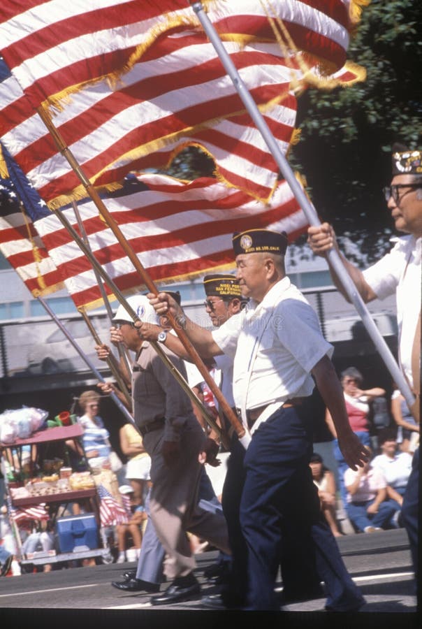 Veterani che marciano con la bandiera americana fotografie stock Veterani che marciano con la bandiera americana fotografie stock