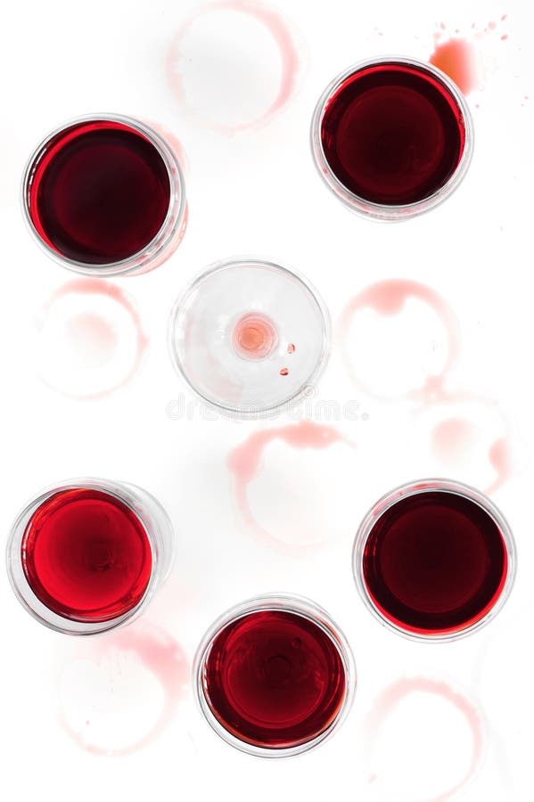 Vetri di vino con vino rosso sulla tavola macchiata immagine stock Vetri di vino con vino rosso sulla tavola macchiata immagine stock