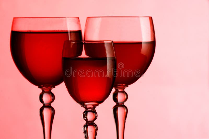 Vetri di vino con vino su un colore rosa immagini stock libere da diritti Vetri di vino con vino su un colore rosa immagini stock libere da diritti