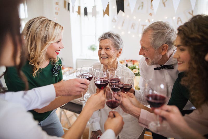 Vetri tintinnanti di una famiglia di diverse generazioni su una festa di compleanno dell'interno della famiglia immagine stock libera da diritti Vetri tintinnanti di una famiglia di diverse generazioni su una festa di compleanno dell'interno della famiglia immagine stock libera da diritti