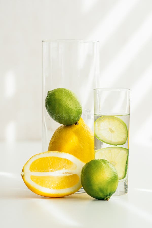 Vetro con acqua e calce, arancia e calce in un vaso di vetro fotografia stock Vetro con acqua e calce, arancia e calce in un vaso di vetro fotografia stock