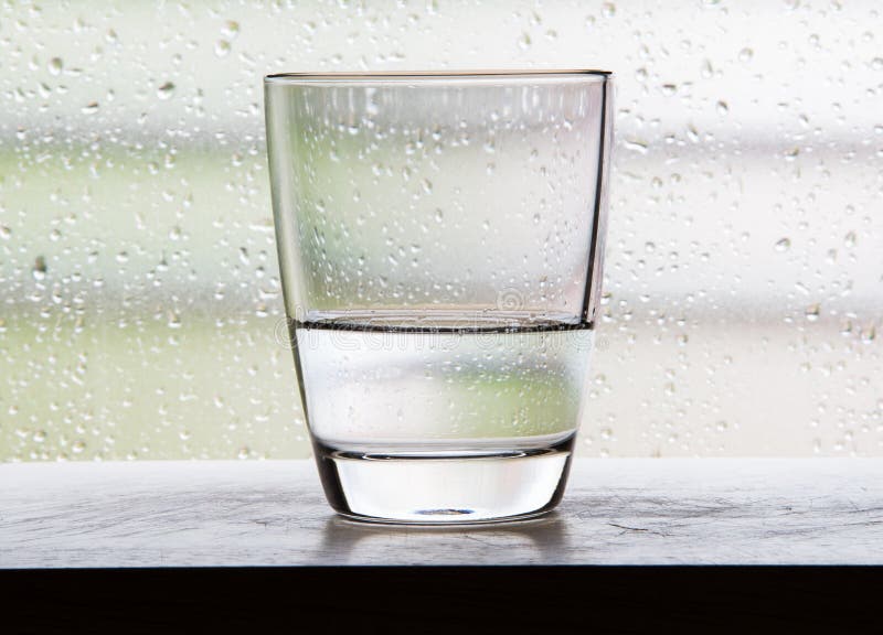 Vetro con le scene mezze del bicchiere d'acqua con il vetro di condensazione