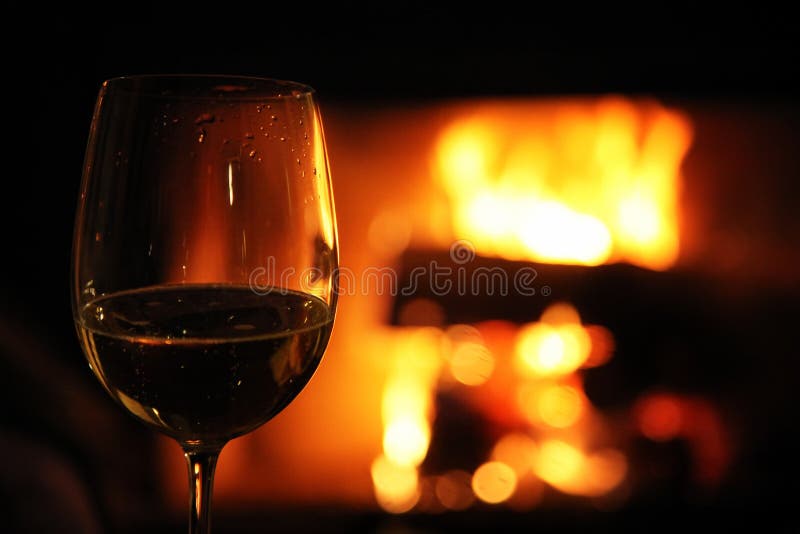 Vetro con vino rosso sui precedenti di fuoco nel camino, fotografie stock Vetro con vino rosso sui precedenti di fuoco nel camino, fotografie stock