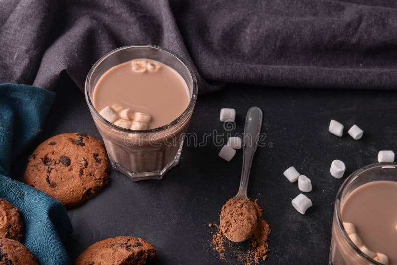 Vetro della bevanda deliziosa del cacao con le caramelle gommosa e molle ed i biscotti sulla tavola fotografie stock Vetro della bevanda deliziosa del cacao con le caramelle gommosa e molle ed i biscotti sulla tavola fotografie stock