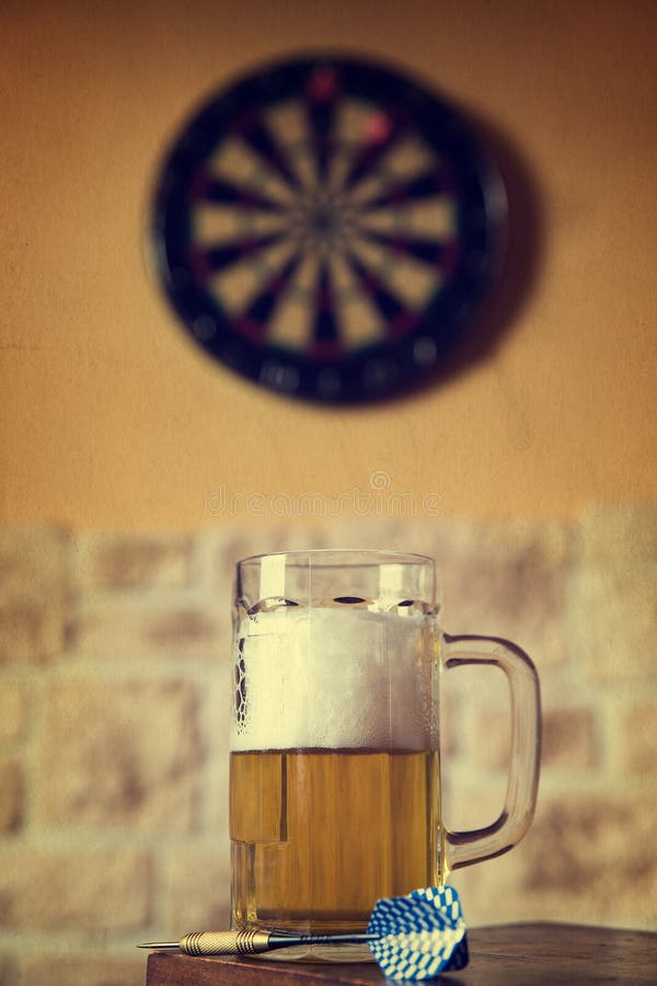 Glass of beer and dartboard in a pub, filtered. Glass of beer and dartboard in a pub, filtered