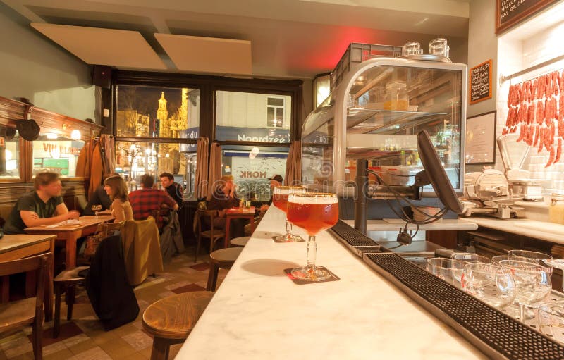 Vetro di birra sul contatore della barra di retro caffè elegante con pranzare bevente della gente fotografia stock Vetro di birra sul contatore della barra di retro caffè elegante con pranzare bevente della gente fotografia stock