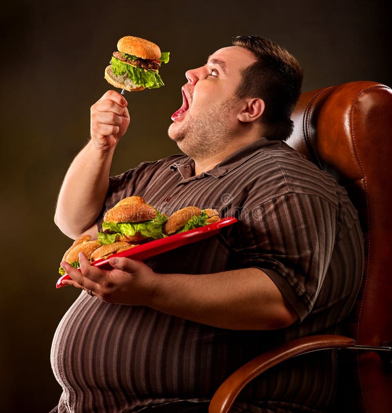 Vette mens die snel voedsel eten hamberger Ontbijt voor te zware persoon royalty-vrije stock foto Vette mens die snel voedsel eten hamberger Ontbijt voor te zware persoon royalty-vrije stock foto