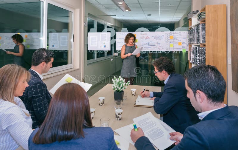 Vettura femminile che guarda la gestione di progetti nell'addestramento del gruppo di affari fotografie stock libere da diritti Vettura femminile che guarda la gestione di progetti nell'addestramento del gruppo di affari fotografie stock libere da diritti