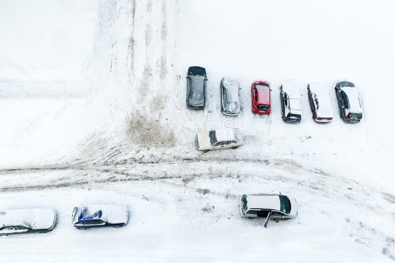 Veículos que estão na coberta do parque de estacionamento do inverno com neve Vista superior