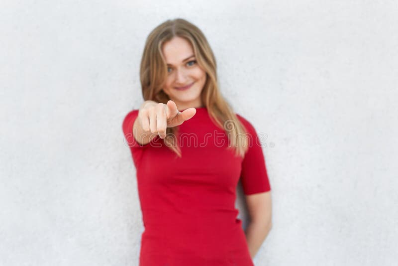 Vi scelgo! Colpo potato della donna in vestito rosso che indica alla macchina fotografica con il dito indice isolato sopra fondo fotografia stock Vi scelgo! Colpo potato della donna in vestito rosso che indica alla macchina fotografica con il dito indice isolato sopra fondo fotografia stock