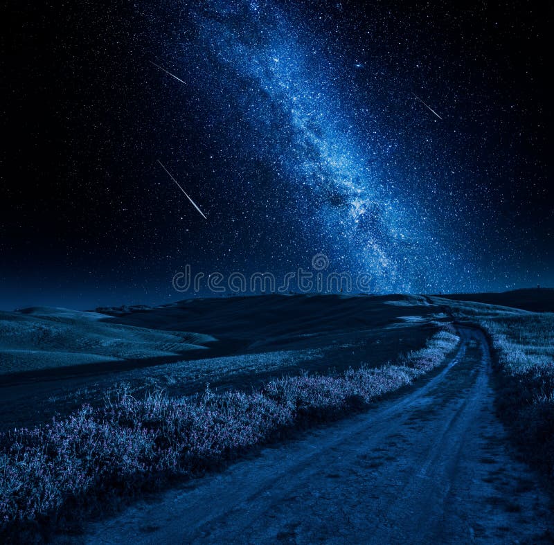 Via Lattea di stordimento sopra la strada campestre alla notte fotografia stock Via Lattea di stordimento sopra la strada campestre alla notte fotografia stock