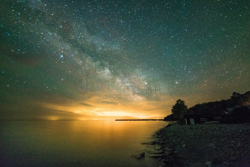 Via Lattea e stelle sopra il lago che mostra litorale e le scogliere a fotografia stock Via Lattea e stelle sopra il lago che mostra litorale e le scogliere a fotografia stock