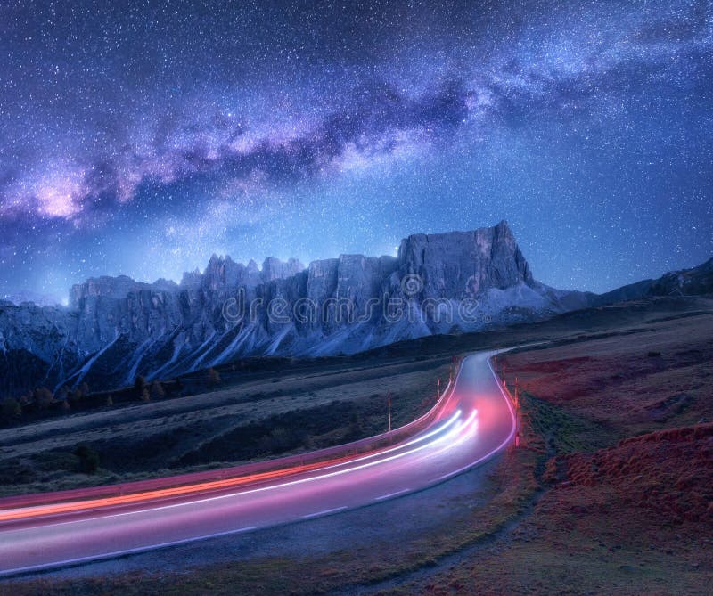 Via Lattea sopra la strada della montagna alla notte nell'estate