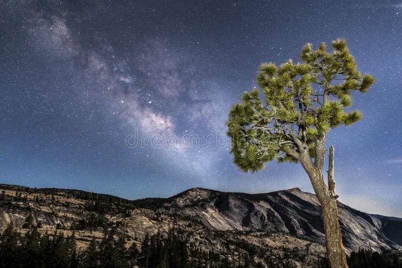 The Milky Way Galaxy stretches across the night sky over a great moonlit granite monolith know as Clouds Rest as seen from Olmsted Point in the high country of California`s Yosemite National Park. The Milky Way Galaxy stretches across the night sky over a great moonlit granite monolith know as Clouds Rest as seen from Olmsted Point in the high country of California`s Yosemite National Park.