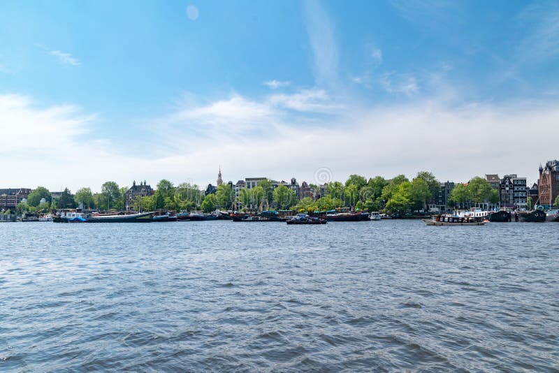 Via navigabile di Oosterdok con imbarcazioni ad Amsterdam, Paesi Bassi immagini stock Via navigabile di Oosterdok con imbarcazioni ad Amsterdam, Paesi Bassi immagini stock
