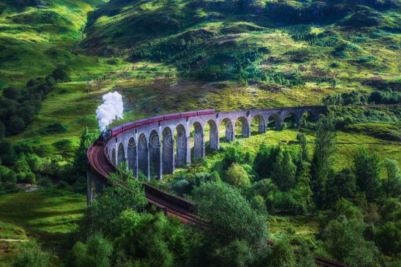 Glenfinnan Railway Viaduct in Scotland with the Jacobite steam train passing over. Artistic vintage style processing. Glenfinnan Railway Viaduct in Scotland with the Jacobite steam train passing over. Artistic vintage style processing.