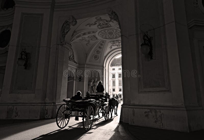 Viagem romântica em um fiacre puxado por cavalos através da porta de Michaelertrakt no centro histórico de Viena, Áustria fotos de stock Viagem romântica em um fiacre puxado por cavalos através da porta de Michaelertrakt no centro histórico de Viena, Áustria fotos de stock