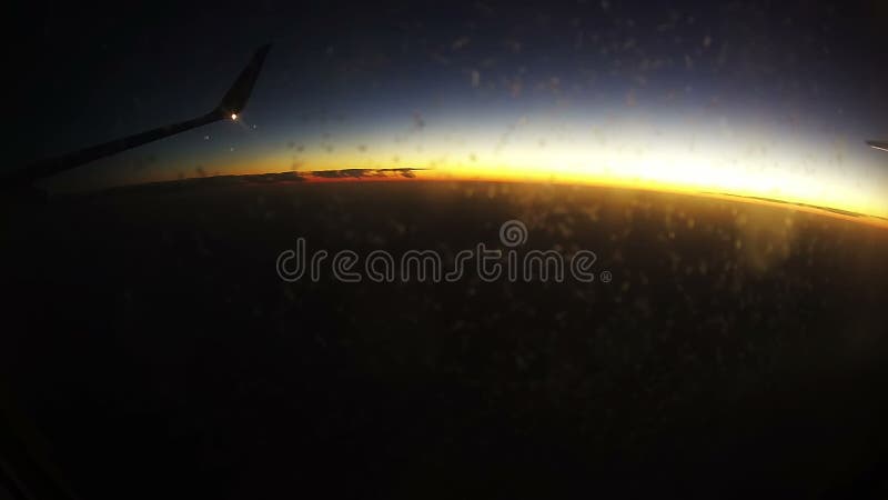 Viaggiando dall'aria Vista attraverso la finestra dell'aeroplano sul fondo di tramonto