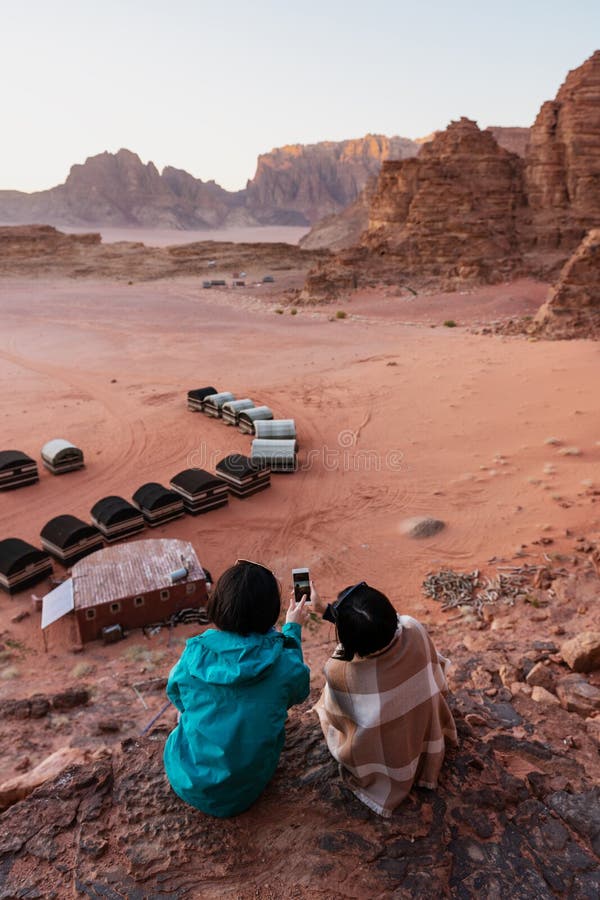 Viaggiando nel deserto di Wadi Rum, la Giordania Prendendo foto dallo smartphone sulla scogliera fotografie stock libere da diritti Viaggiando nel deserto di Wadi Rum, la Giordania Prendendo foto dallo smartphone sulla scogliera fotografie stock libere da diritti