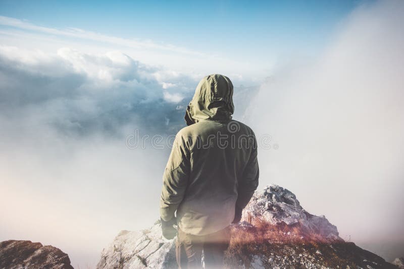 Viaggiatore dell'uomo che sta sulla sommità della montagna fotografia stock libera da diritti Viaggiatore dell'uomo che sta sulla sommità della montagna fotografia stock libera da diritti