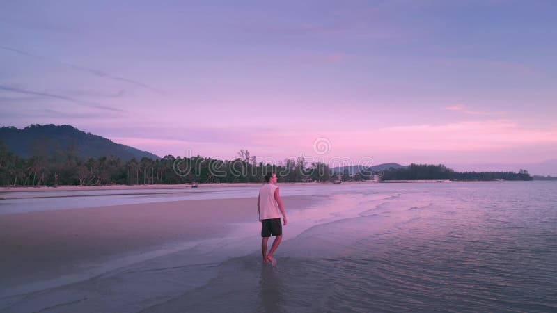 Viaggiatore di vacanza sulla spiaggia di mare al tramonto rosa rilassato le vacanze estive. caucasico