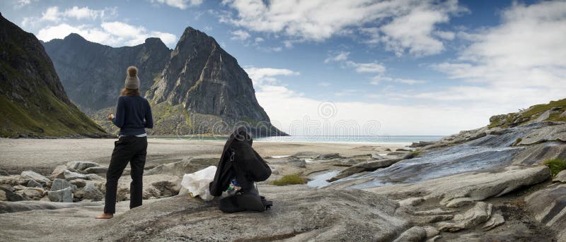 Viaggiatore femminile che riposa sulle isole di un Lofoten della spiaggia immagine stock libera da diritti Viaggiatore femminile che riposa sulle isole di un Lofoten della spiaggia immagine stock libera da diritti
