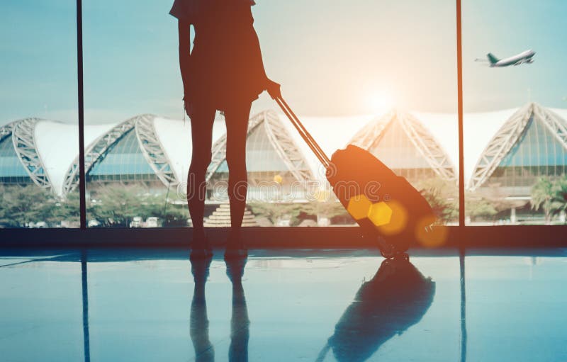 Viaggio della donna della siluetta con bagagli che guardano senza finestra fotografie stock libere da diritti Viaggio della donna della siluetta con bagagli che guardano senza finestra fotografie stock libere da diritti