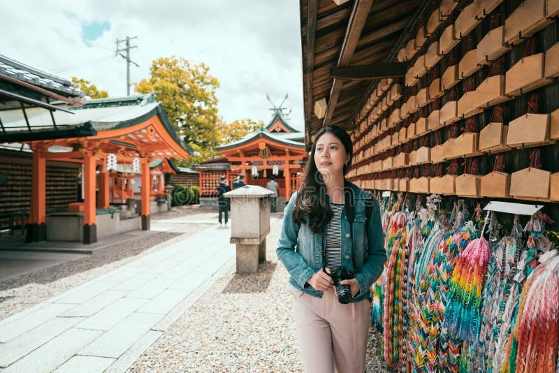 Viajante asiático da menina que anda ao longo da parede rezando fotos de stock