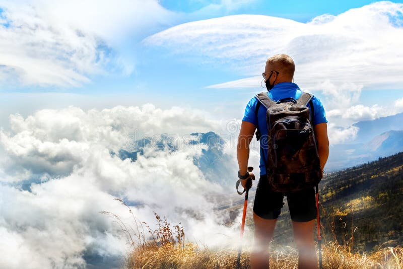 Viajante desportivo do indivíduo com trouxa em um fundo de um céu bonito com as nuvens nas montanhas Acima das nuvens indonésia fotos de stock Viajante desportivo do indivíduo com trouxa em um fundo de um céu bonito com as nuvens nas montanhas Acima das nuvens indonésia fotos de stock