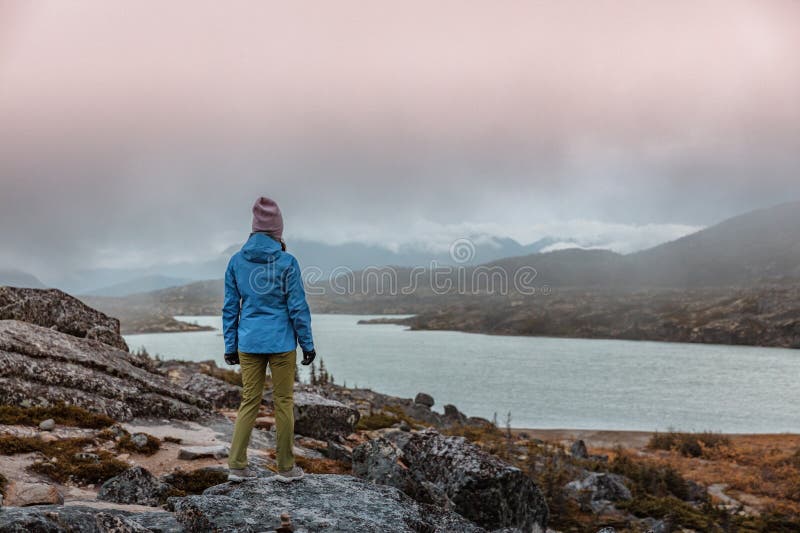 Viajar sozinha em alaska durante o frio outono. mulher turista caminhando perto do lago no norte