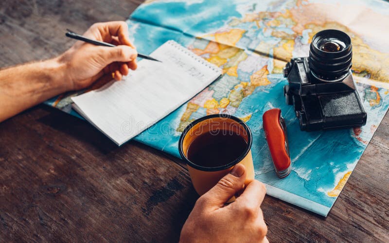 Viaje con el mapa, visión superior del planeamiento del hombre del viajero Él bebe el café imagen de archivo libre de regalías Viaje con el mapa, visión superior del planeamiento del hombre del viajero Él bebe el café imagen de archivo libre de regalías