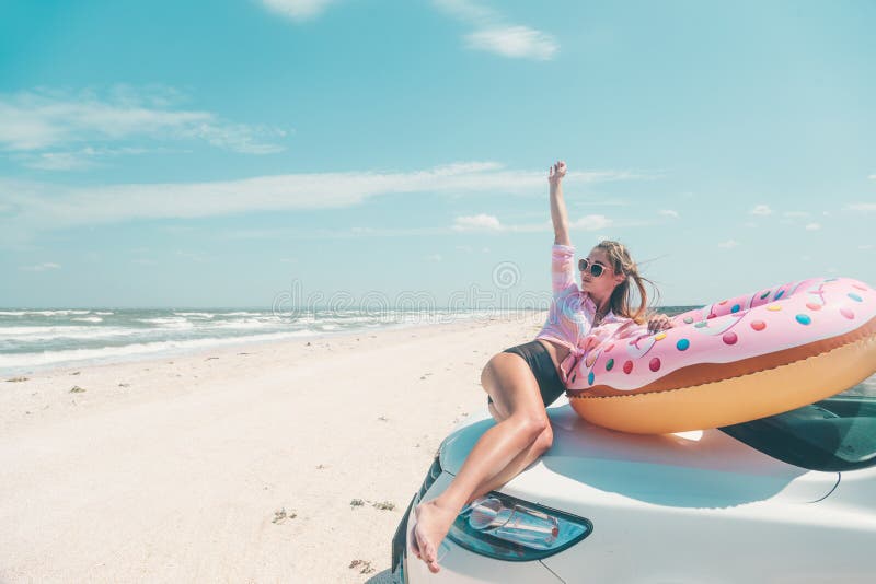 Girl relaxing on donut lilo on the beach. Playing with inflatable ring. Car trip to summer holiday idyllic, freedom concept. Girl relaxing on donut lilo on the beach. Playing with inflatable ring. Car trip to summer holiday idyllic, freedom concept