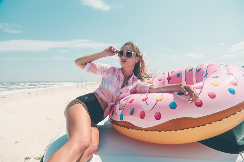 Girl relaxing on donut lilo on the beach. Playing with inflatable ring. Car trip to summer holiday idyllic. Girl relaxing on donut lilo on the beach. Playing with inflatable ring. Car trip to summer holiday idyllic