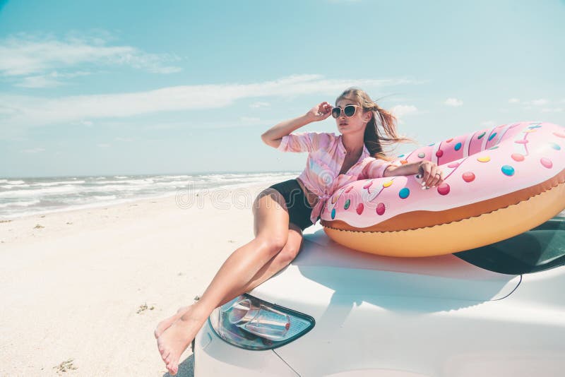 Girl relaxing on donut lilo on the beach. Playing with inflatable ring. Car trip to summer holiday idyllic. Girl relaxing on donut lilo on the beach. Playing with inflatable ring. Car trip to summer holiday idyllic